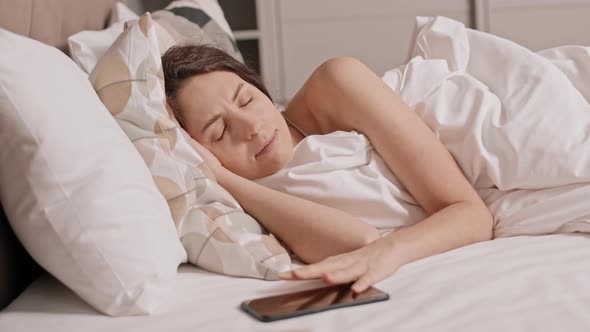 Woman Waking up Looking at Smartphone