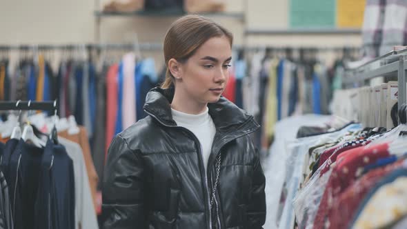 A Young Girl Choosing and Looking at Clothes in the Store