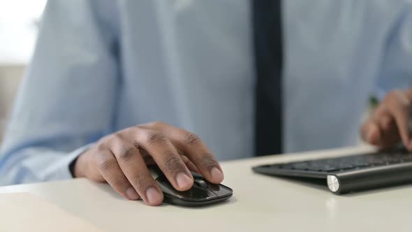 Hands of African Man Using Mouse and Keyboard Close Up