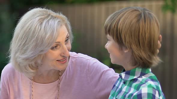 Cheerful Grandmother Talking to Little Boy and Smiling at Camera, Happy Family