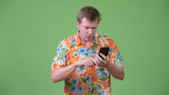 Young Handsome Tourist Man Using Phone and Giving Thumbs Down