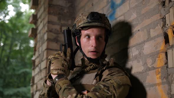 Army Soldier Taking Aim with Pistol Gun in Building