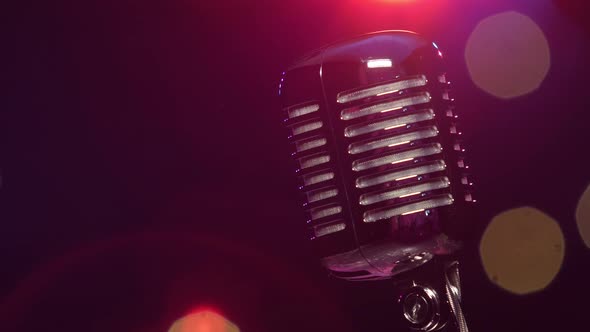 Vintage Microphone Against Dark Blurry Background with Bright Flashing Lights