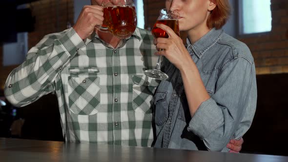 Lovely Couple Embracing While Drinking Beer Together at the Restaurant