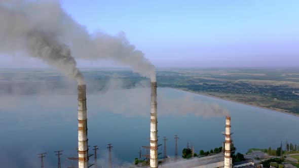 Aerial view of coal power plant high pipes with black smokestack polluting atmosphere