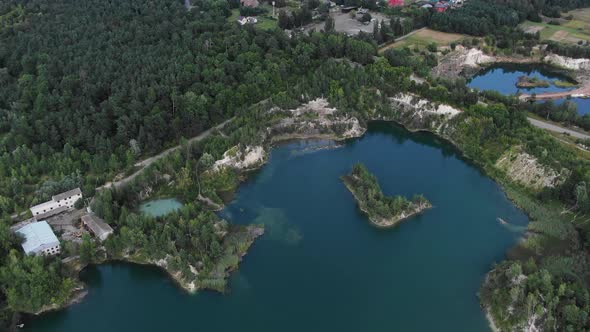 Aerial View of lake with Beautiful Water in a Quarry Surrounded by Forest and Small Town