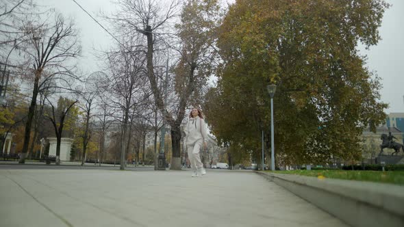 Beautiful Woman In Headphones Dancing On City Street