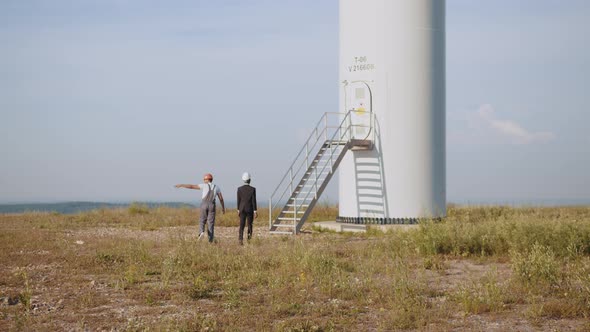 African American Inspector in Black Suit and White Helmet Talking with Indian