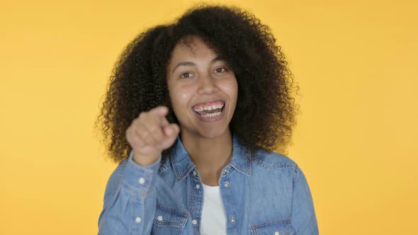 African Woman Pointing with Finger, Yellow Background 