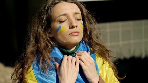 Portrait of a Woman with a Ukrainian Flag on His Shoulders