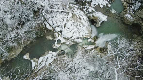 Waterfall Flowing From White Rocks Into a Lake in the Forest