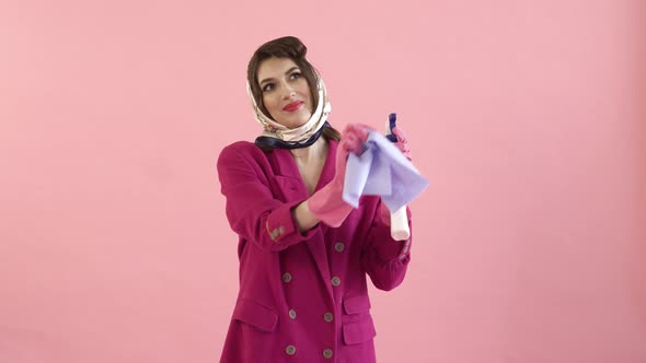 Stylish Woman with a Headscarf on Her Head Washes the Windows