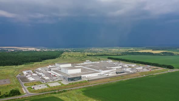 Birds-eye view to the modern industrial buildings. Large manufacturing plant under the blue sky