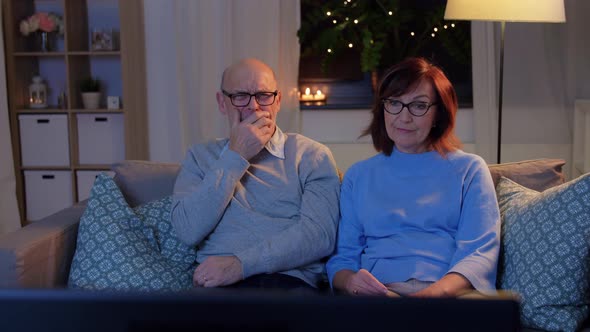 Senior Couple Turning Tv Off at Home in Evening