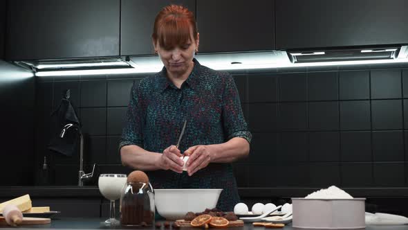 Woman is breaking raw eggs