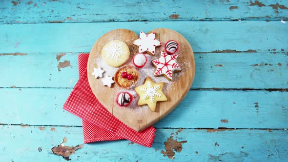 Christmas cookies with napkin on heart shape wooden board