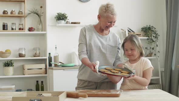 Woman and Her Granddaughter Enjoying Handmade Cookies