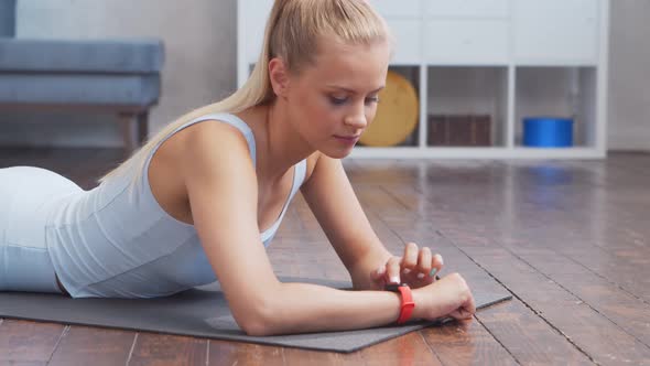 Young and sporty girl in sportswear is doing exercises at home.