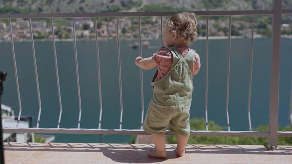 Baby Toddler Boy Standing on Balcony at Tropical Beach Resort