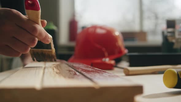 Woman Builder Varnishing Wooden Board Closeup