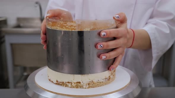 Closeup of a Pastry Chef Preparing a Cake Takes Out a Metal Round Shape