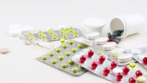 Multi-colored pills and capsules lie on the table. Scattered drugs. Cold and flu season