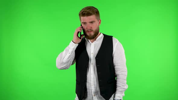 Man Angrily Speaks on the Phone, Proves Something on Green Screen.