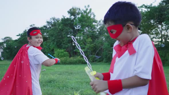 Happy Asian boys playing bubbles at the park