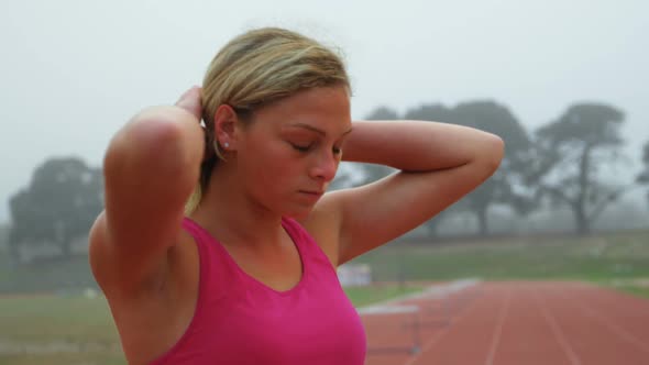 Front view of young female athlete tying her hair at sport venue 4k4k