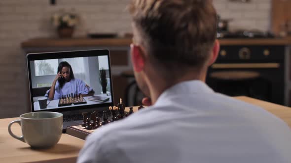 Young Couple Playing Chess Online Using Video Chat