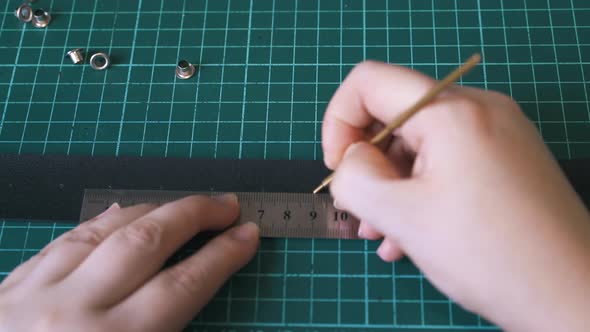 Skilled Designer Draws Dots on Black Leather Belt Template