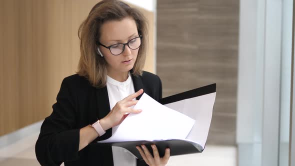 Business Woman In Wireless Earphones Talking On Smartphone