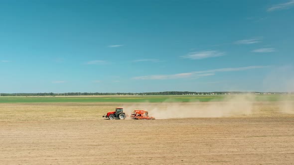 Aerial View Tractor With Seed Drill Machine Sowing The Seeds For Crops In Spring Season