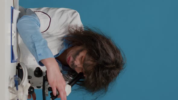 Vertical Video Goofy Mad Female Researcher Using Microscope at Desk