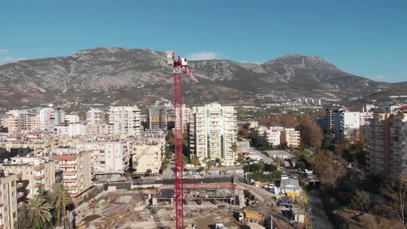 Building of residential buildings. High construction crane working on construction site.