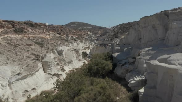 Aerial Dolly Through Beautiful Sarakiniko Lunar Volcanic Canyon with Dry Desert Surrounding in Milos