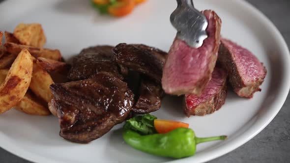 Cooking beef steaks on the stove with tongs