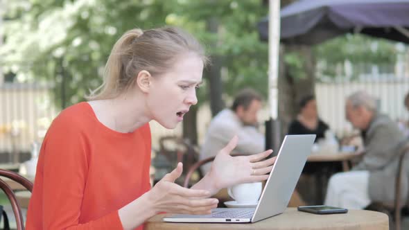 Young Woman Frustrated By Failure Sitting in Cafe Terrace