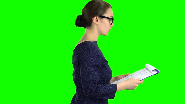Businesswoman Comes with a Paper Tablet on the Street. Green Screen. Side View