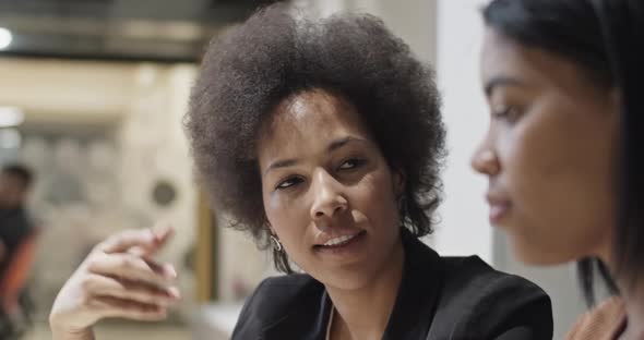 Black Woman Showing Data on Tablet to Colleague