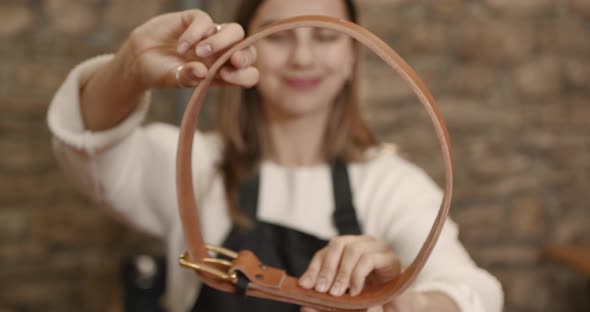 Young Woman Craftsperson Making a Leather Belt