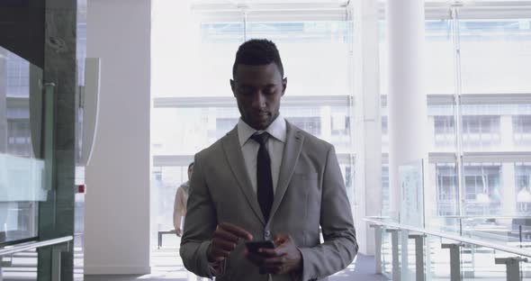 Businessman using mobile phone in the corridor at office 4k