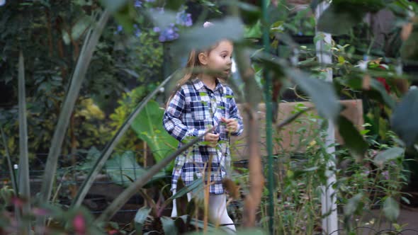 Funny Girl Runs Skipping Along the Path in the Garden