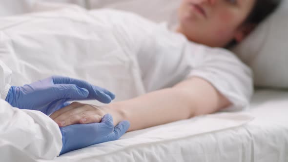 Hospital Worker in protective Uniform Supporting Female Patient