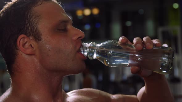 Muscular man drinking water from a bottle