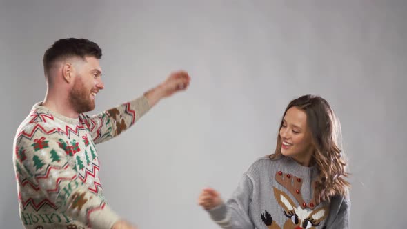 Happy Couple in Christmas Ugly Sweaters Dancing 22