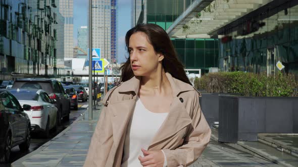 Brownhaired Woman Walks at Street in City