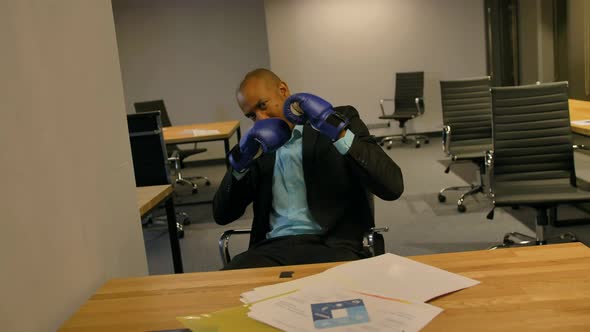 Sporty Fighty Leader in Business Concept. Afro-American Businessman Sitting with Boxing Gloves in