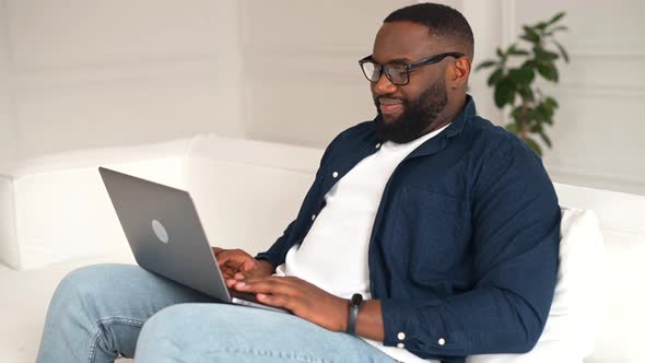 Male Student Using Laptop Enjoying Chatting Online