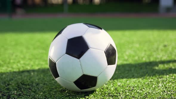 Football Ball that Lying on the Special Green Covering while Player Kicking it Towards the Gate